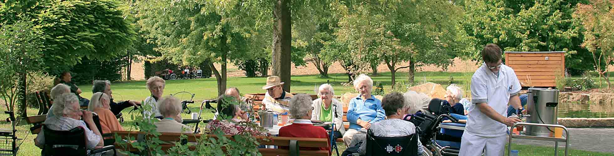 Seniorengruppe beim Kaffeetrinken im Garten