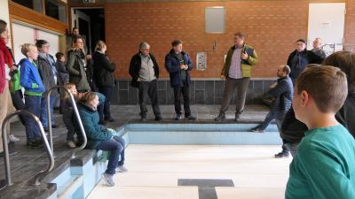 Menschen befinden sich in einer Schwimmhalle.