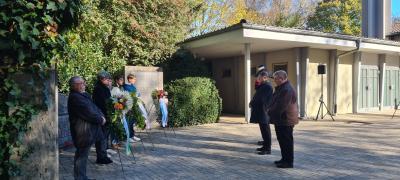 Städtische Vertreter und Schüler auf einem Friedhof