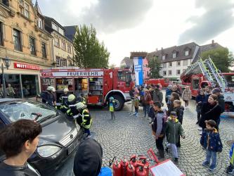 Die Feuerwehr präsentiert sich auf dem Marktplatz, Zuschauer stehen drum herum